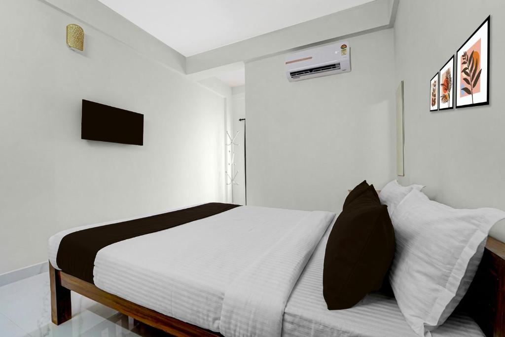 a white bedroom with a bed with white walls at Hotel O Moonlight Residency in Trivandrum