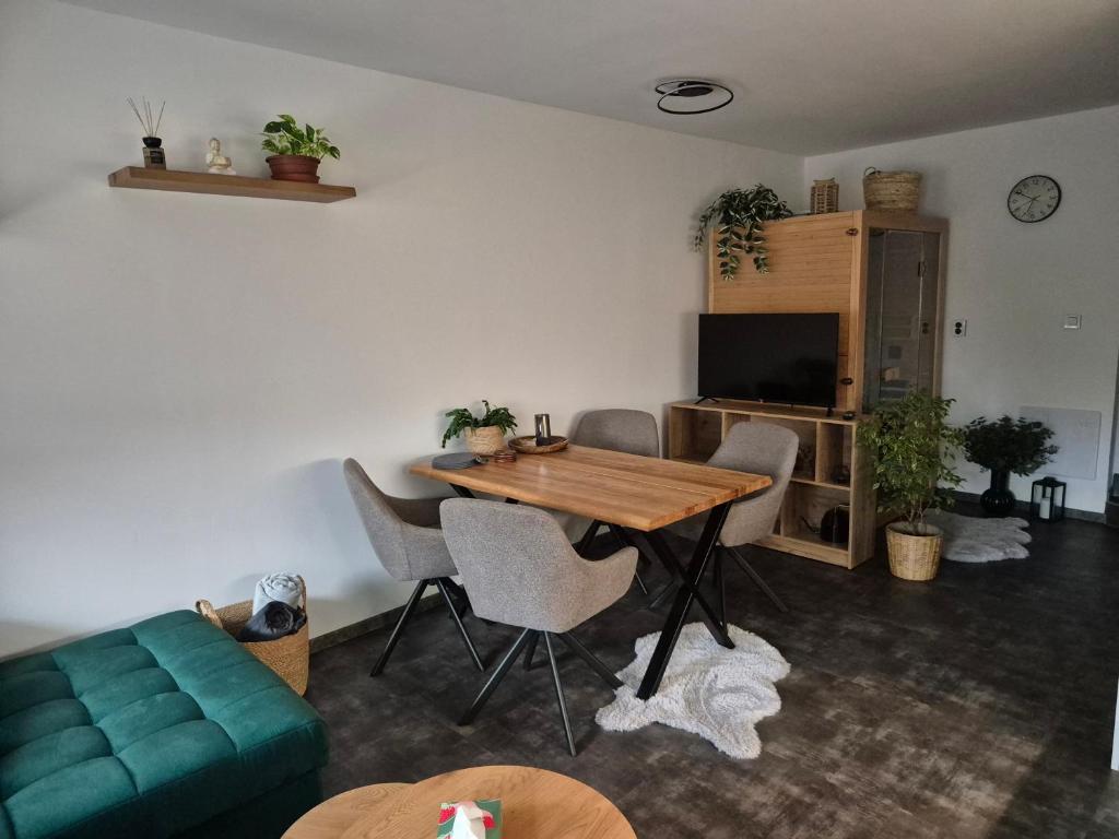 a living room with a table and a green couch at Apartmán U Lanovky in Kramolín
