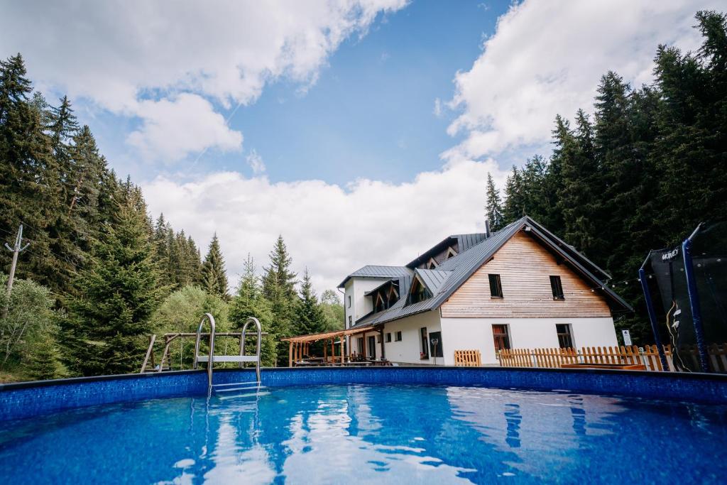 a large swimming pool in front of a house at Chata Františkov in Kvilda