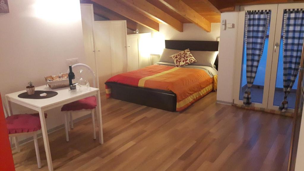 een slaapkamer met een bed, een tafel en een bureau bij La Mansardina in Matera