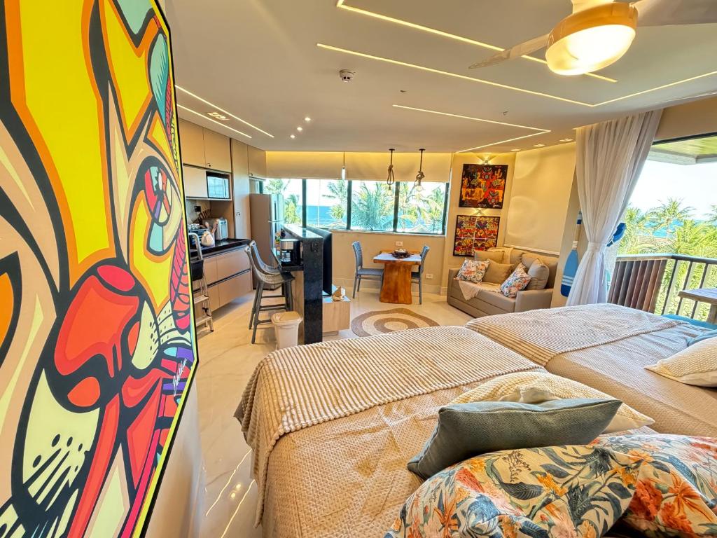 a bedroom with two beds and a living room at Marulhos resort Muro Alto flats Premium frente ao mar in Porto De Galinhas