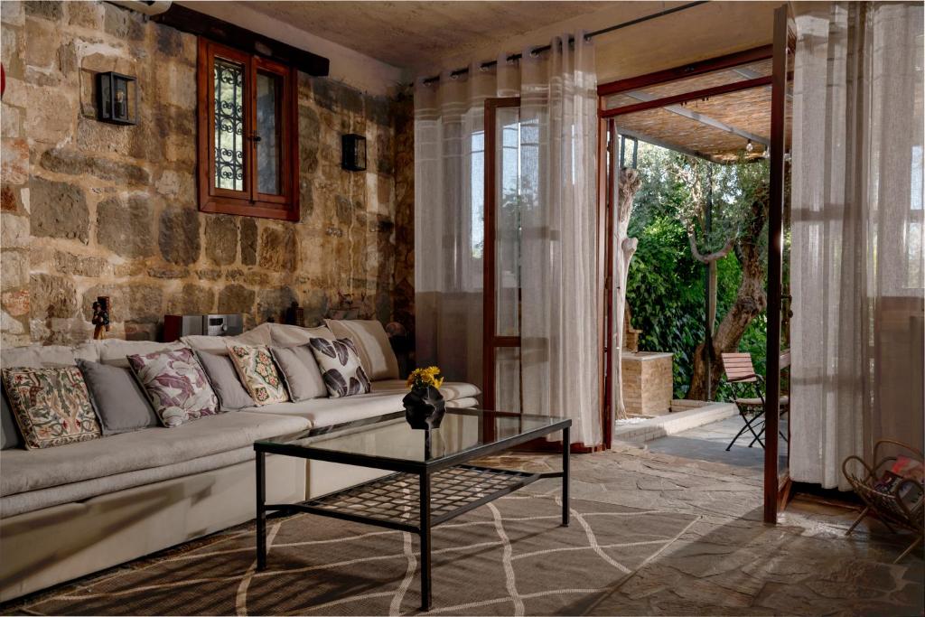 a living room with a couch and a glass table at Villa Gioia - Secret gem with private garden in Katastárion