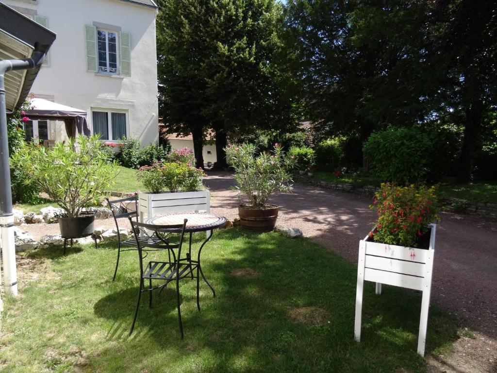 - une table et des chaises dans la cour d'une maison dans l'établissement Maison Gille, à Nuits-Saint-Georges