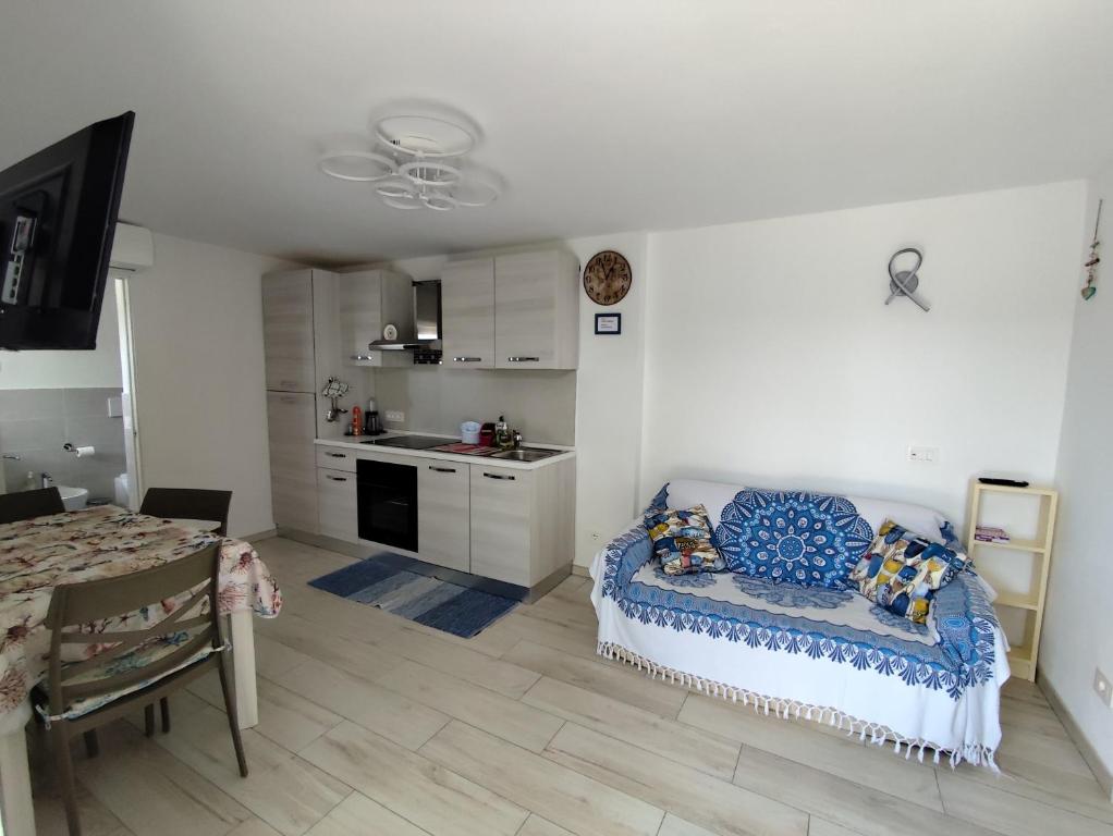 a living room with a couch and a kitchen at La Casina Procchio loc I Marmi in Procchio