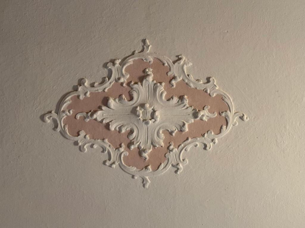 a ceiling with a silver design on a wall at Zucca s home in Baveno