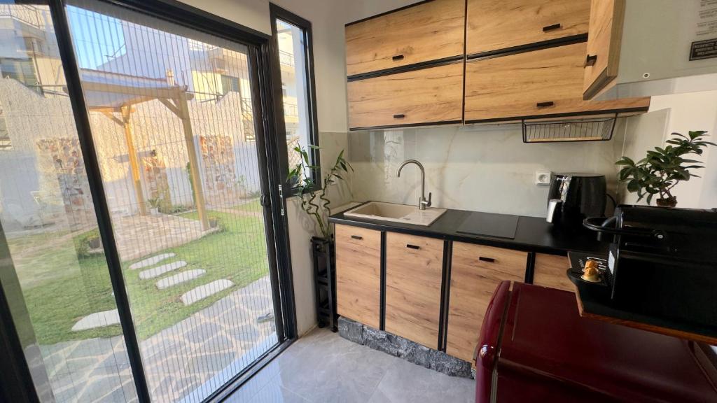 a kitchen with a sink and a large window at Salamina Urban Escape C in Paloúkia