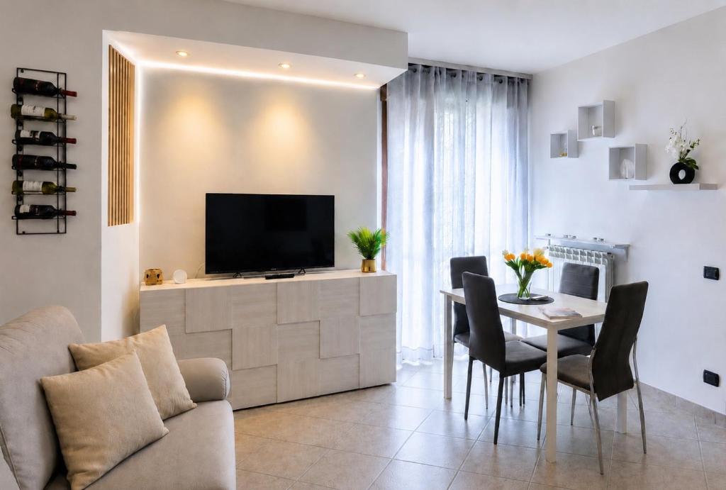 a living room with a television and a table with chairs at Stile e comfort! in Trecate