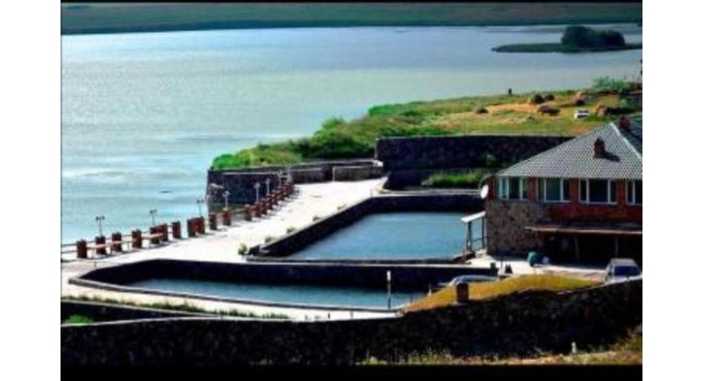 a large pool of water next to a building and the ocean at Sagamo in Sagamo