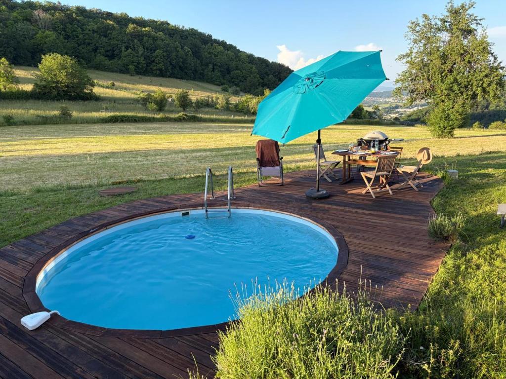 a swimming pool with a table and an umbrella at Basel Landskron Haus in Leymen