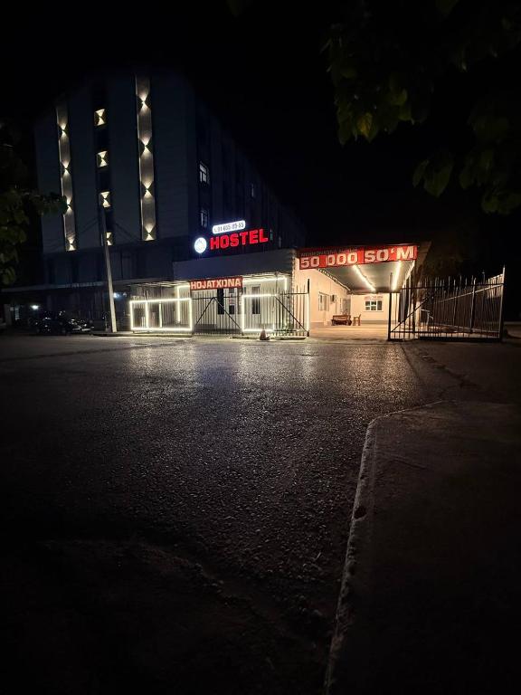 a night time view of a large building with lights at Noor house hostel in Fergana