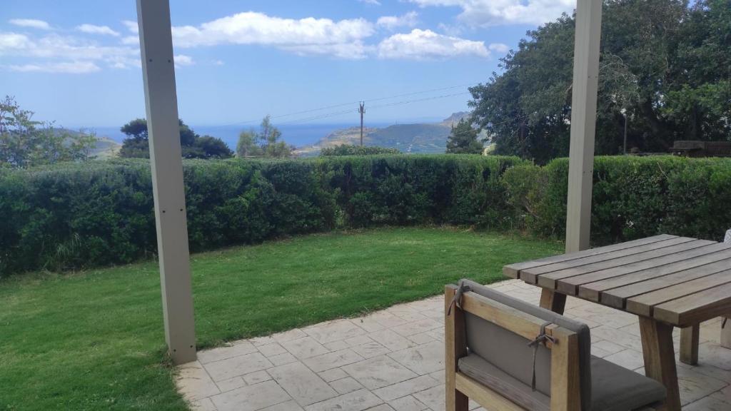 a porch with a wooden table and a view of a yard at Villa Aias- Private Olive Grove Retreat in Plakias