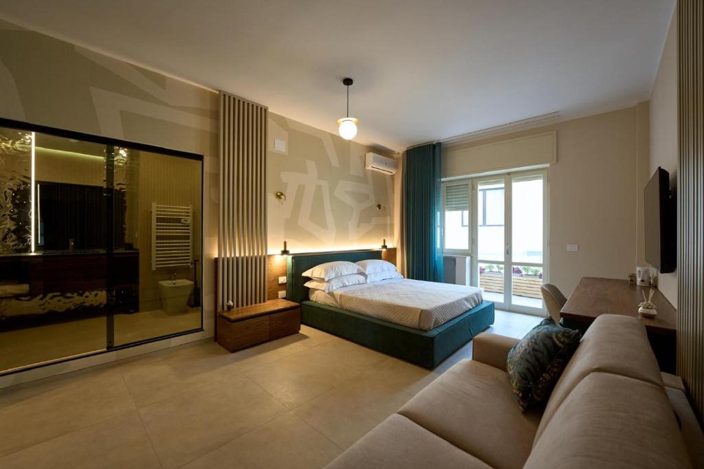 a hotel room with a bed and a couch at Oltremare Luxury Suites in Otranto