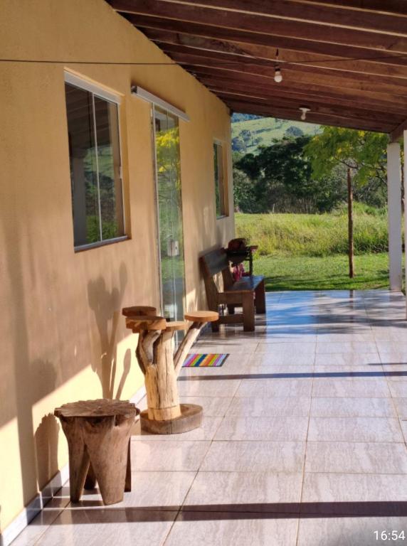 a porch of a house with a table and a chair at Casa amarela in Gonçalves