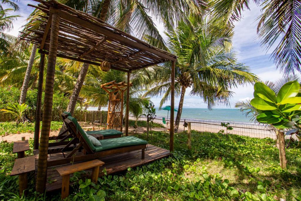 a gazebo with a hammock and the ocean at Casa Caroá - Chalé 3 in Japaratinga