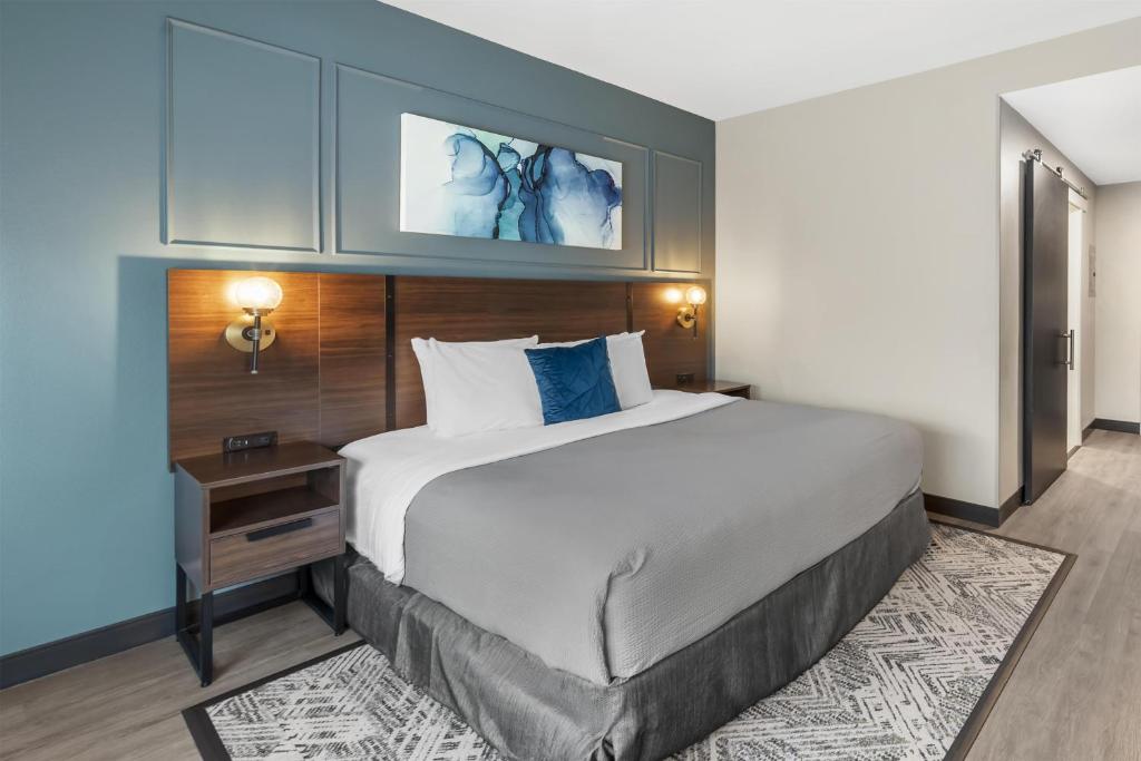 a hotel room with a large bed and a table at Best Western Plus Rialto in Rialto