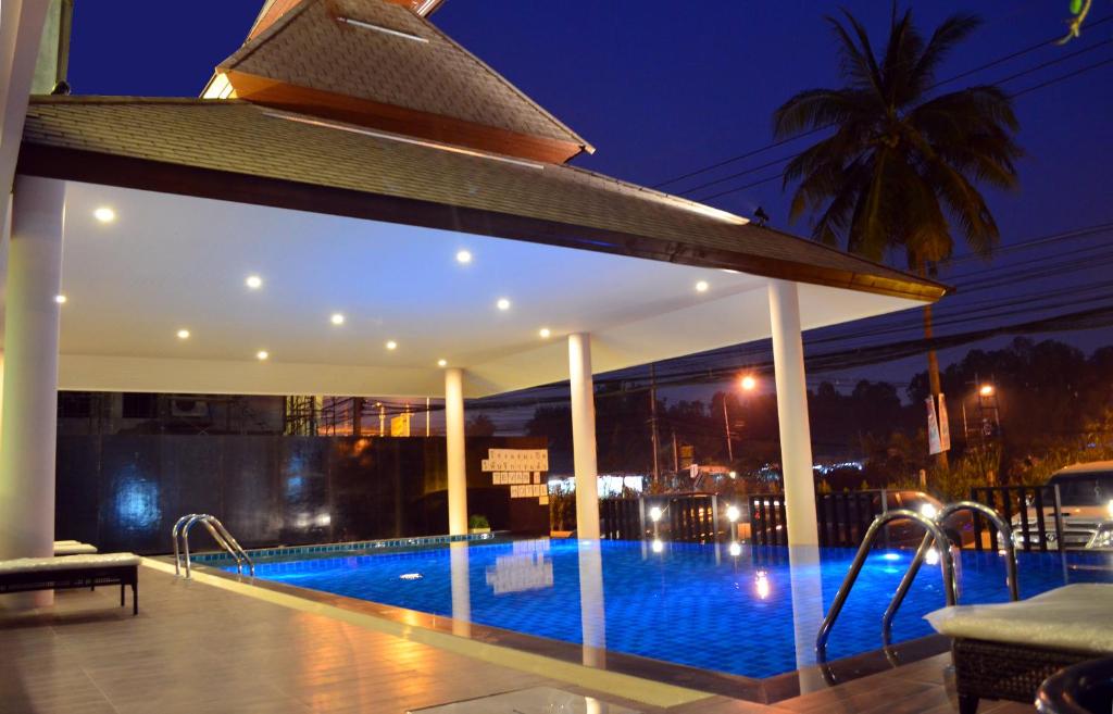 a swimming pool in a building at night at Tevan Jomtien Pattaya in Jomtien Beach