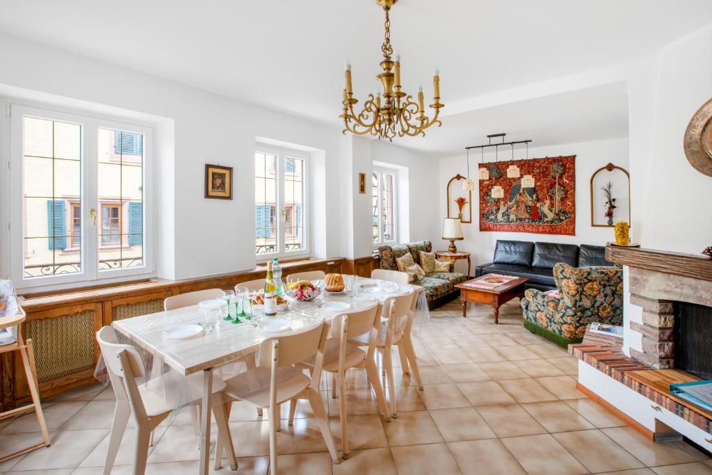 a living room with a table and a fireplace at Gîte du forgeron - 6 à 8 personnes - Centre Alsace - Saint-Hippolyte in Saint-Hippolyte