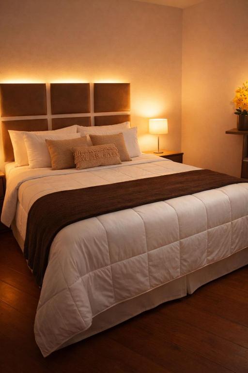 a large bed in a room with a large white bed at Suíte Aconchegante com Hidromassagem Jardim Esplanada in São José dos Campos