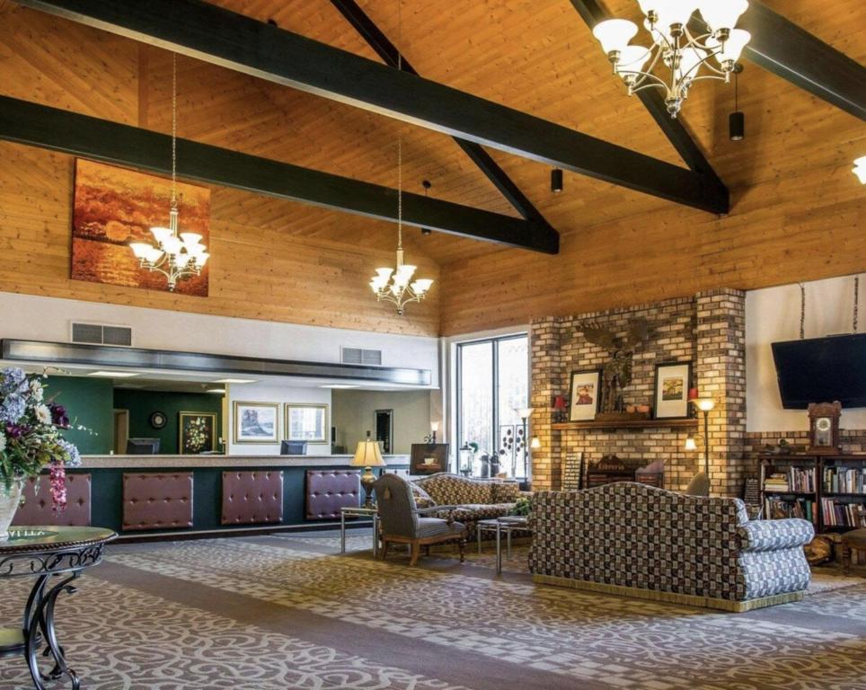 a lobby with couches and chairs and a tv at Quality Inn & Suites Escanaba North in Escanaba