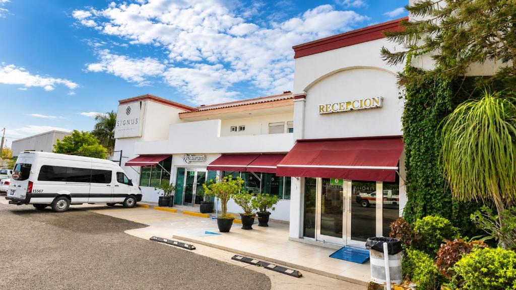 a white van parked in front of a building at Hotel Maioris El Diez Culiacan in Culiacán