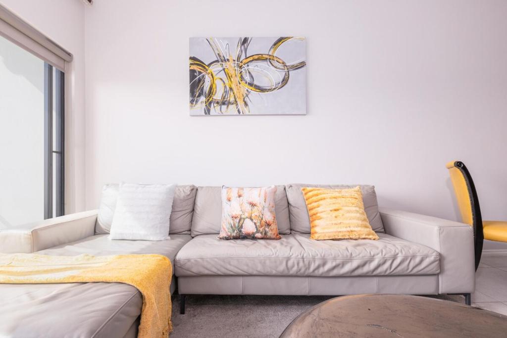 a living room with a couch and a painting on the wall at Zoe Lodge in Midrand