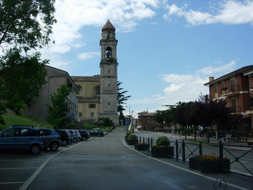 サン・ゼーノ・ディ・モンターニャにあるCasa Vacanze San Zeno di Montagnaの通りの真ん中にある時計塔のある建物