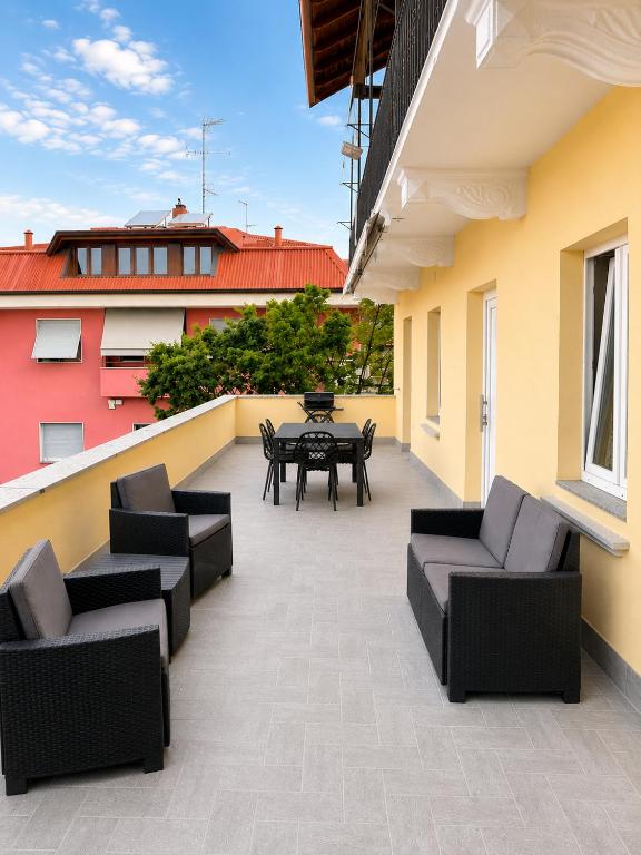 a patio with couches and a table on a balcony at La Terrazza, comfort e relax tra i laghi in Borgomanero