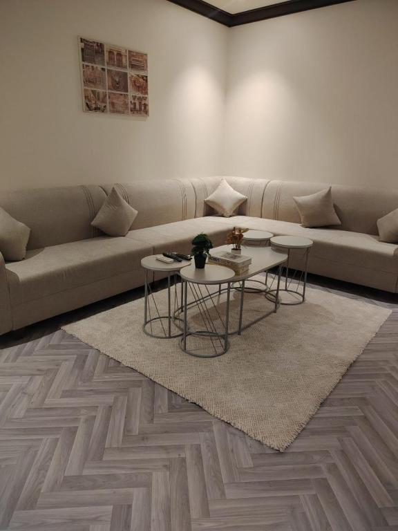 a living room with a couch and two tables at Sukoon Apartment شقة سكون 2 in Buraydah