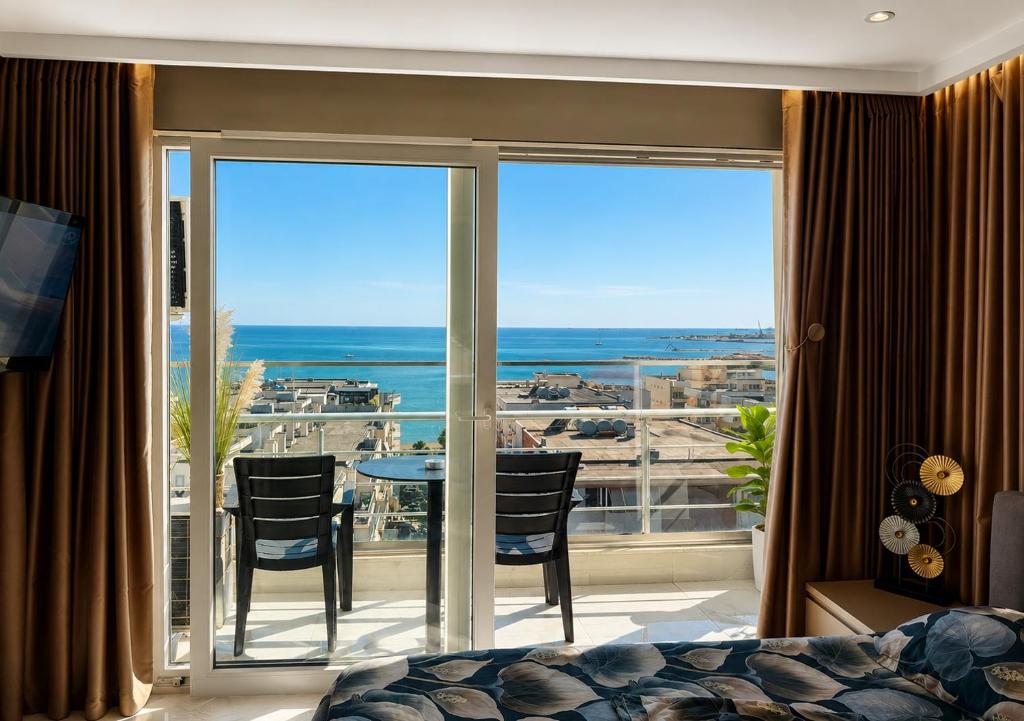 a bedroom with a balcony with a view of the ocean at Eri Apartments in Durrës