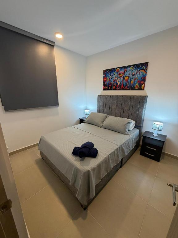 a bedroom with a bed with a painting on the wall at Espectacular alojamiento in Gaira