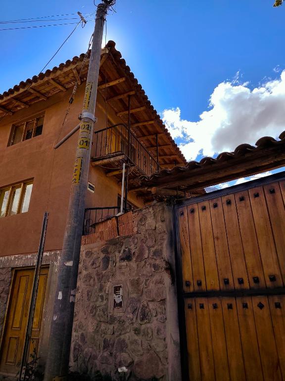 a house with a wooden gate and a pole at Casa Rumiwillka in Urubamba