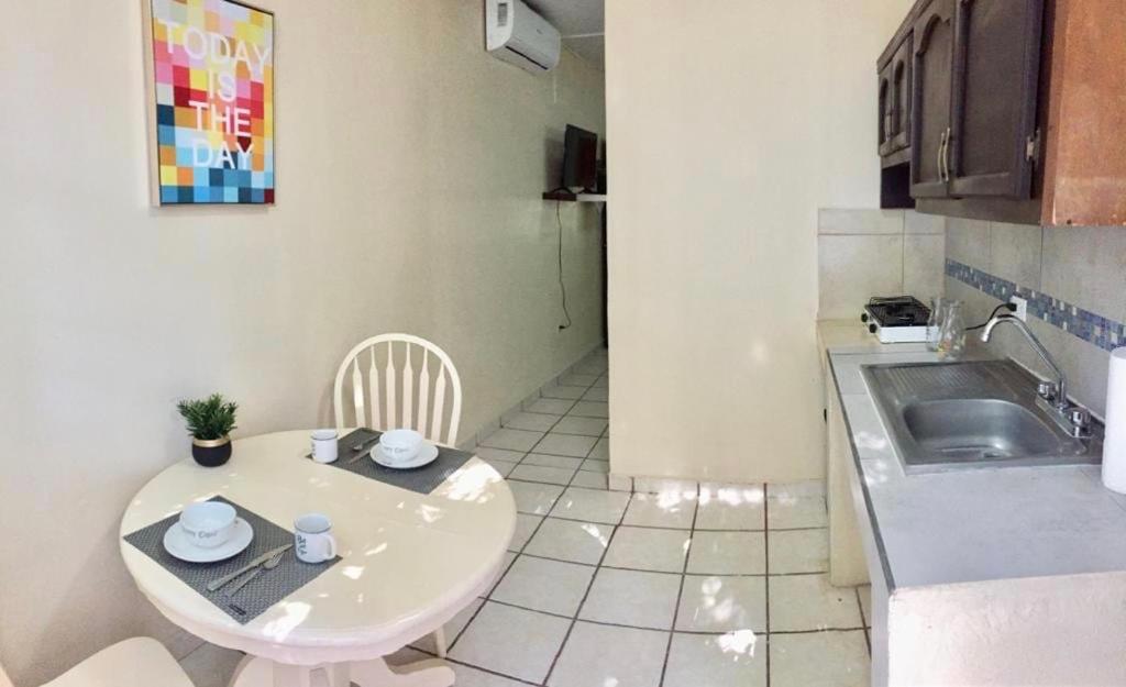 a small kitchen with a table and a sink at Estudio #1 a 10 min del malecon in La Paz