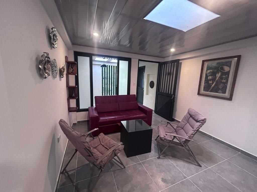 a living room with a purple couch and two chairs at Park Suite in Ibagué