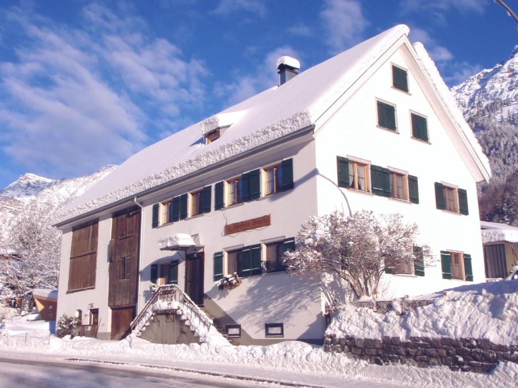 a large white building with snow on the ground at Gruppenhaus Braz in Innerbraz
