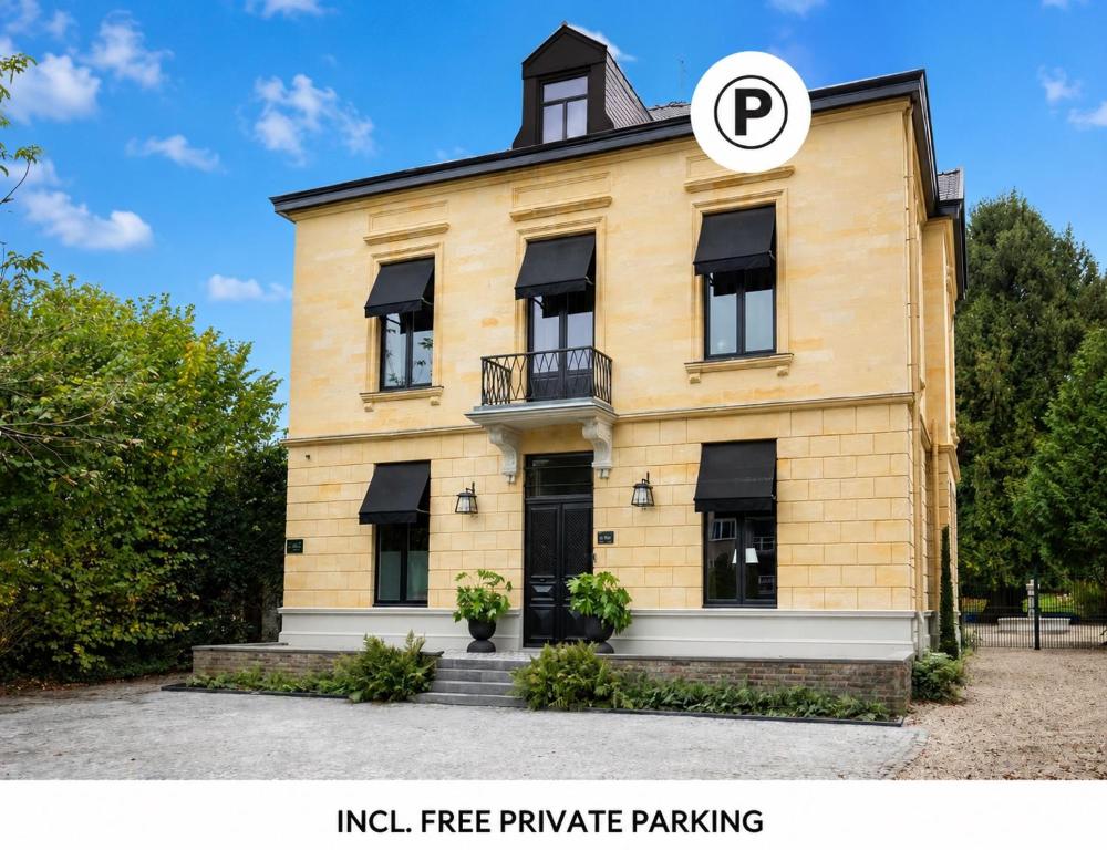 a yellow brick building with a black roof at Villa V - Petit Hôtel in Valkenburg