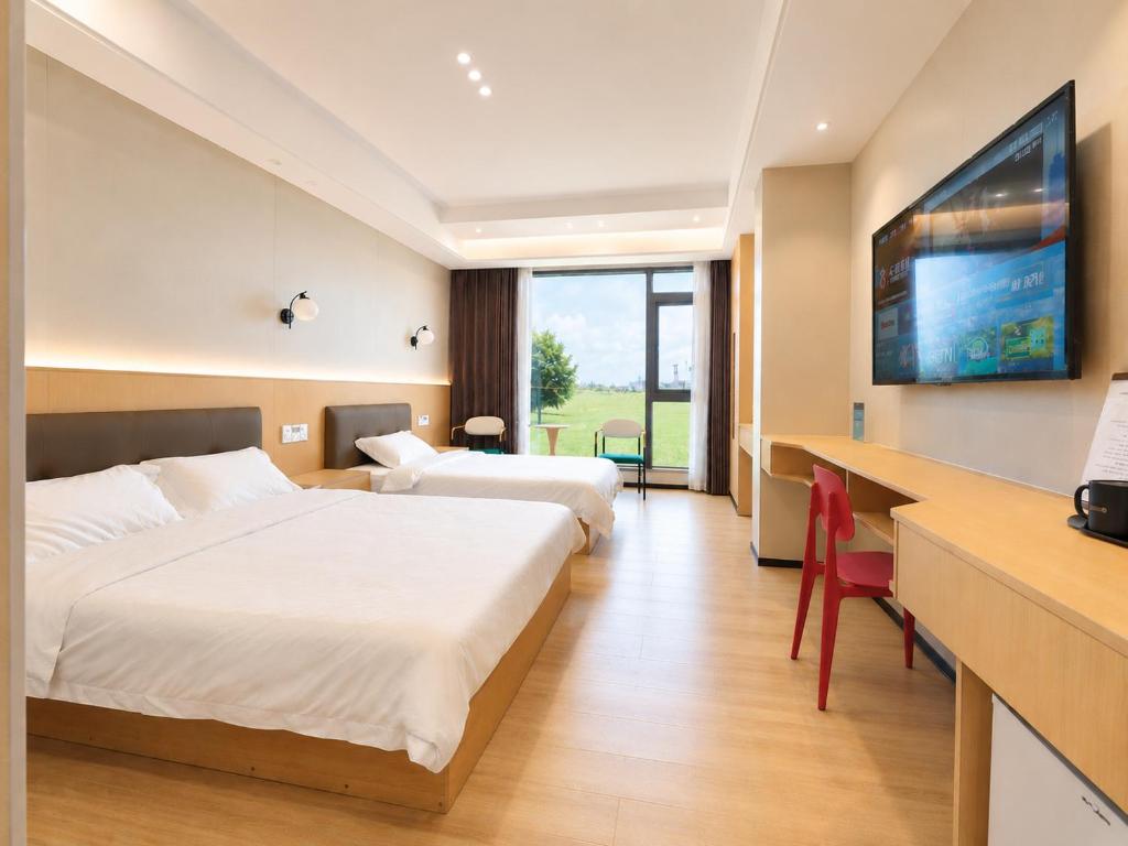 ein Hotelzimmer mit zwei Betten und einem Schreibtisch in der Unterkunft Fantasy Inn in Nuku‘alofa