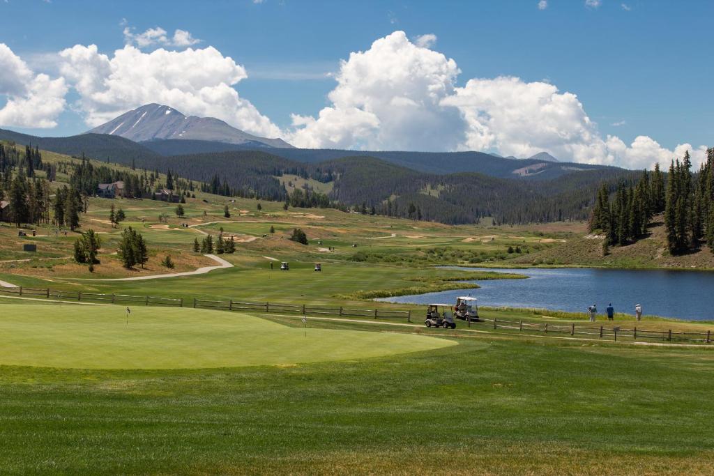 a golf course with a lake and mountains in the background at Flying Dutchman #1158 in Keystone