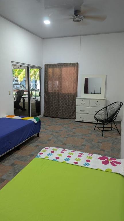 a bedroom with a bed and a chair and a rug at WinMen in El Sunzal
