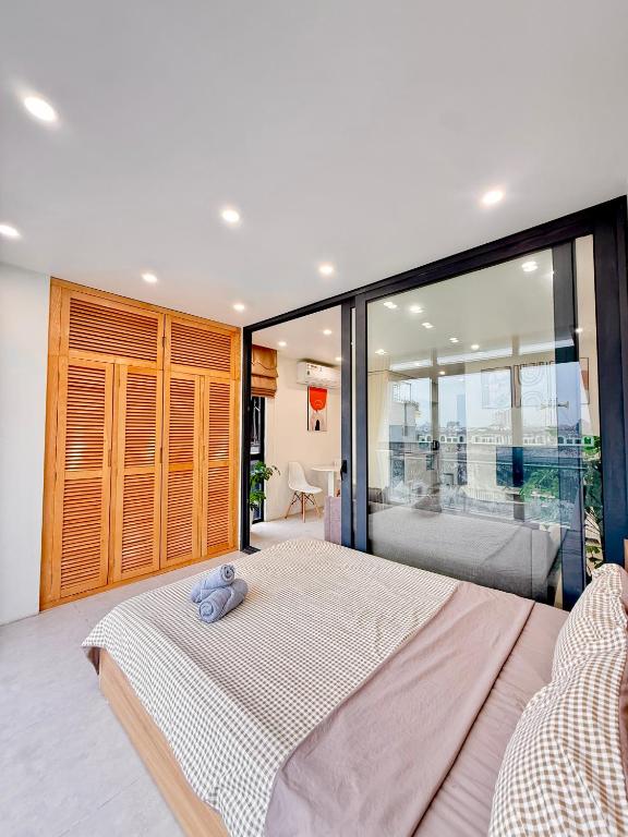 a bedroom with a large bed and a large window at Nest West Lake - Apartment Hà Nội in Hanoi