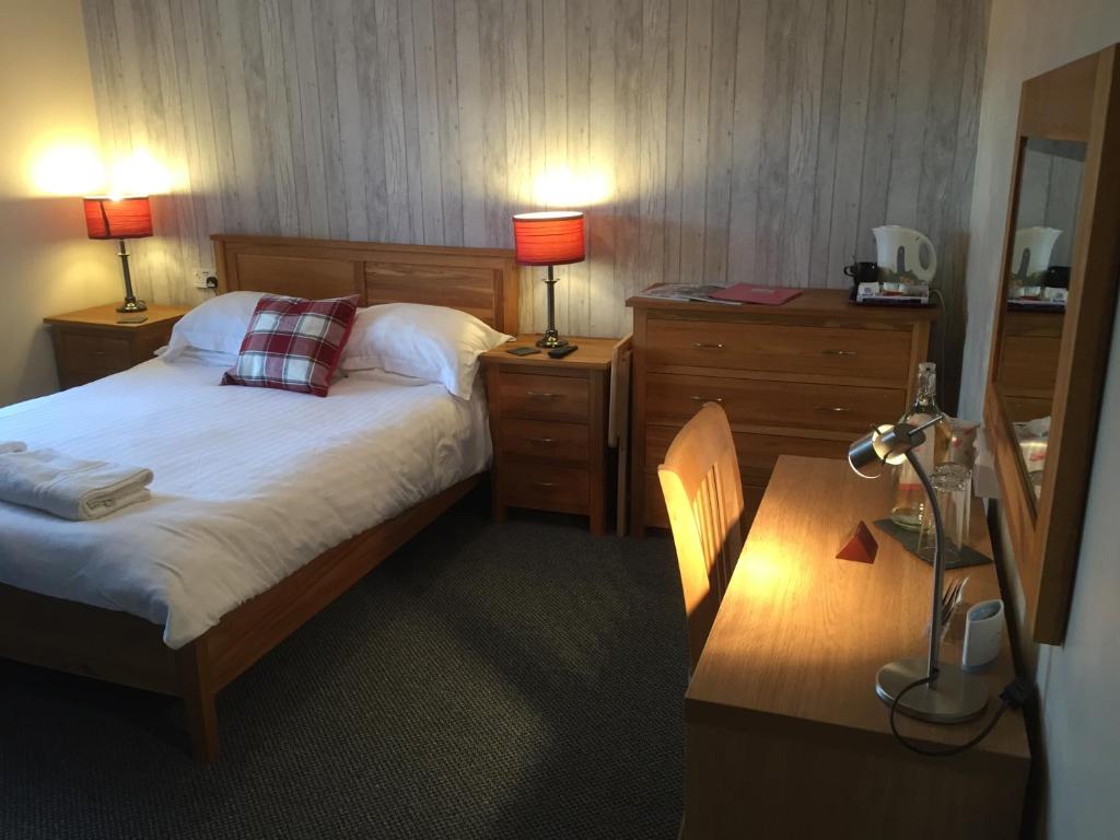a hotel room with two beds and a lamp at Acorn Guest House in Penrith