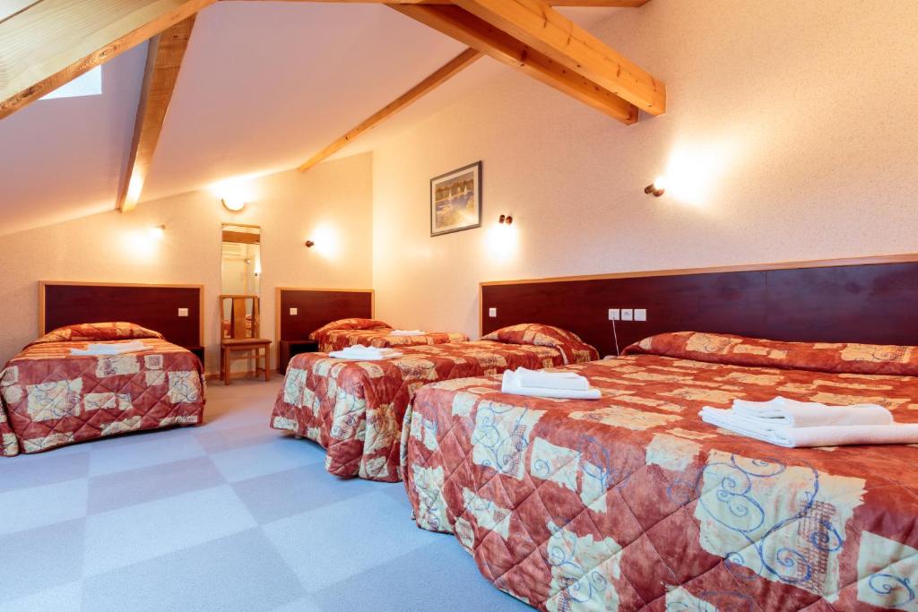 a hotel room with three beds in a room at Les Hirondelles in Orcines