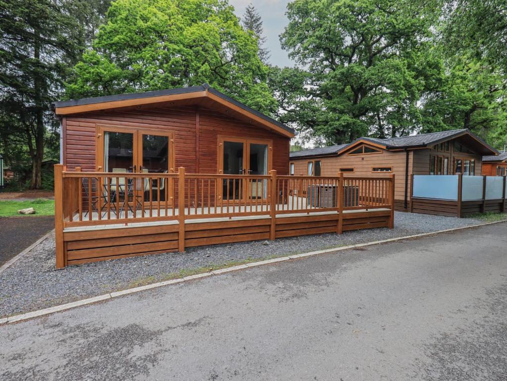 a large wooden cabin with a large deck at Ridgway Lodge in Windermere