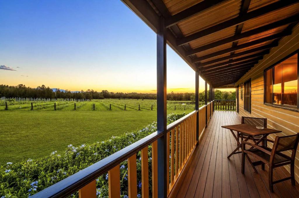 a porch of a house with a table and chairs at Stay at Shiraz in Pokolbin
