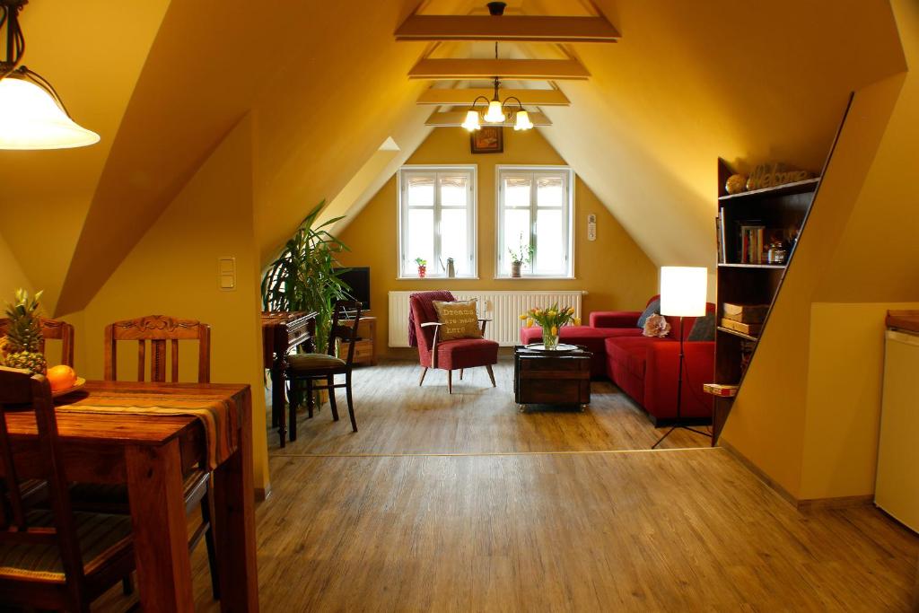 sala de estar con paredes amarillas y sofá rojo en Ferienwohnungen Stobenstraße, en Quedlinburg
