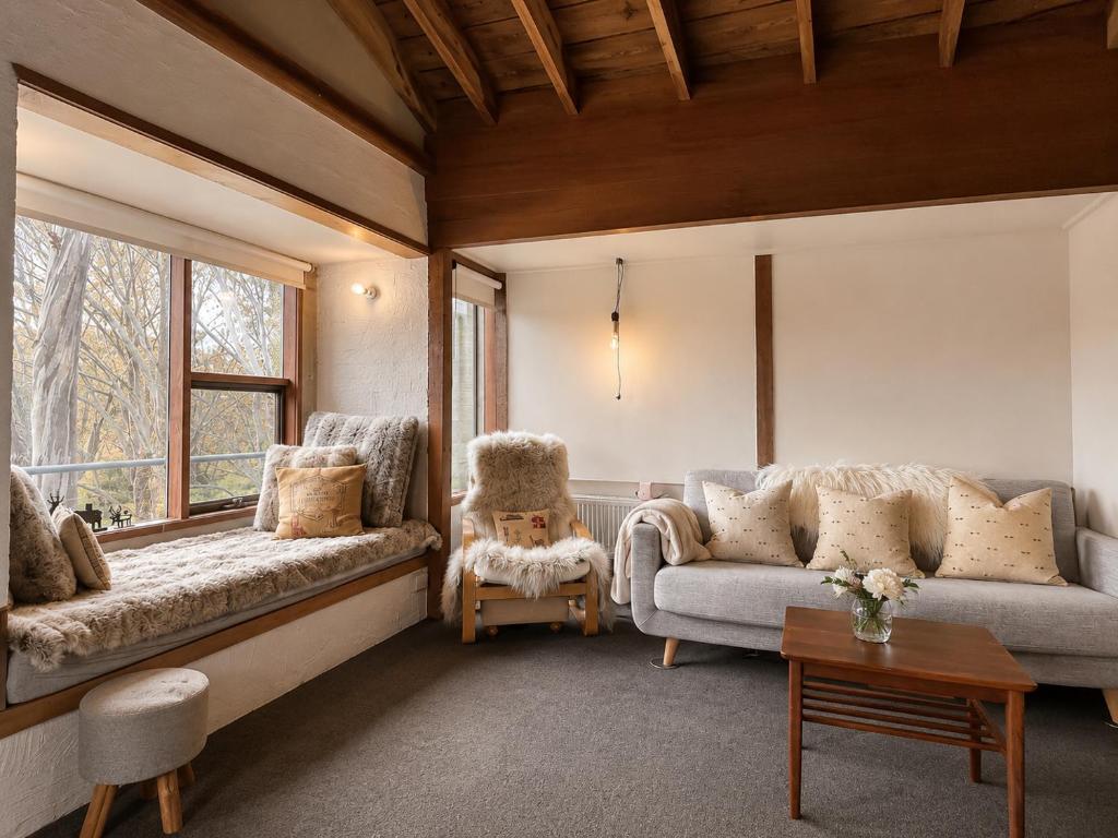 a living room with two couches and a window at Snow Gums Apartment 16 in Dinner Plain