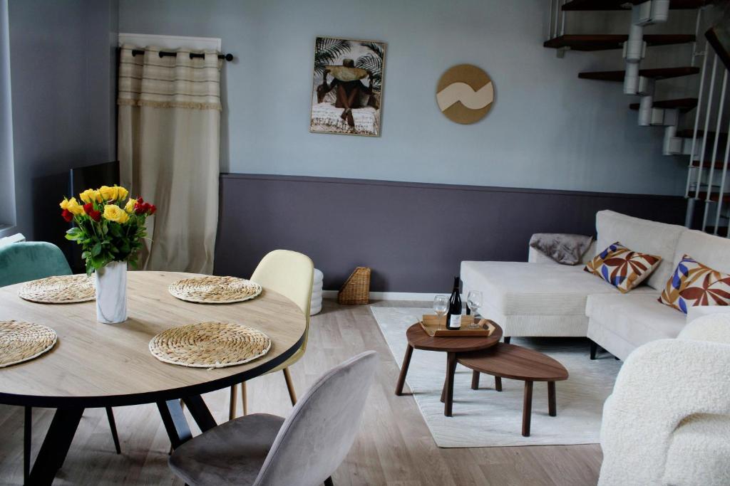 a living room with a table and a couch at Maison de charme in Bourgueil