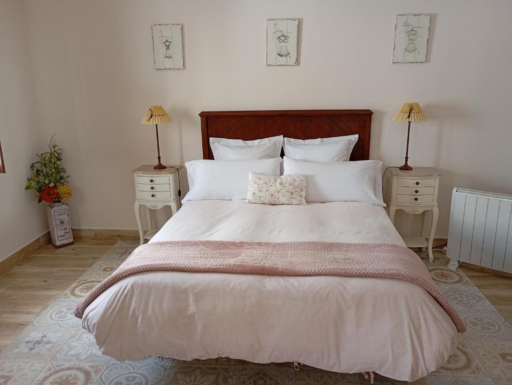 a bedroom with a large white bed with two night stands at Casa Rural Bellamonte in Belmonte
