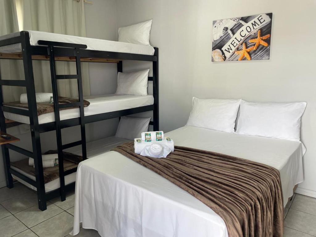 a bedroom with two bunk beds and a bed with towels at Pousada Siri do Mar in Pontal do Paraná