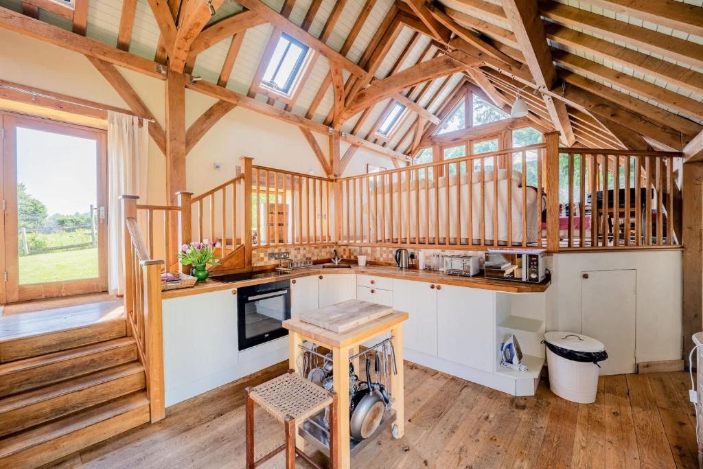 a large kitchen with wooden walls and wooden beams at Airy Barn Conversion Private Parking & Garden in Burrington