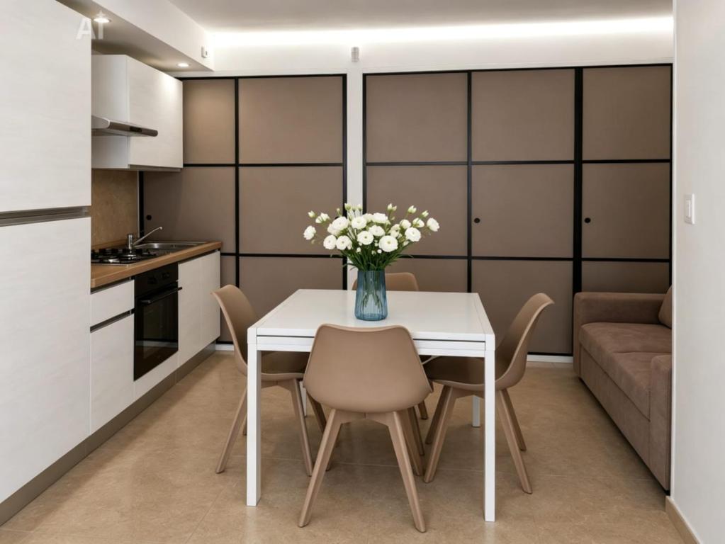 a kitchen and dining room with a white table and chairs at Dimora Azzurra in Pachino